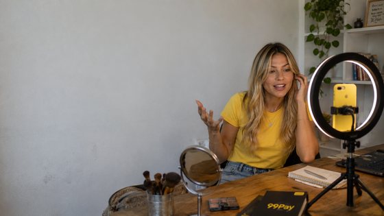 Criadora filmando na mesa 99Pay